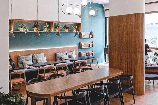 Meja bersama dan area duduk di Kana Cafe Bandung